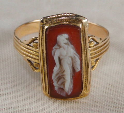 アンティーク・アクセサリー＞リング＞カメオ　conch shell（巻貝）／ゴールド　1920年＞巻貝に女性をデザインしたカメオのリング。ハープをデフォルメしたようなリングのゴールドにシェルの赤が映えます。